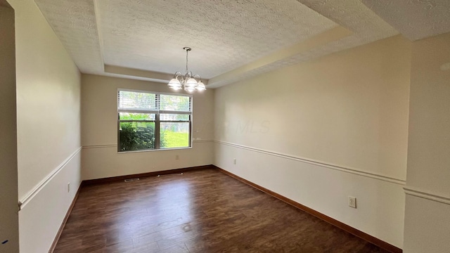 624 Village Park Dr, Powell, OH 43065 - spare room featuring a textured ceiling, a tray ceiling, dark wood finished floors, and a chandelier