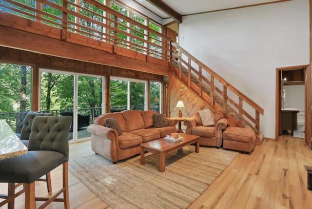 1275 Taos Ln, Sugar Grove, OH 43155 - living room featuring a high ceiling, wood-type flooring, wood walls, stairway, and beamed ceiling