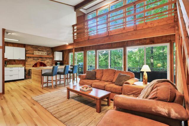 1275 Taos Ln, Sugar Grove, OH 43155 - living room with wood walls, light wood-type flooring, and a high ceiling