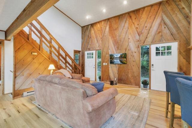 1275 Taos Ln, Sugar Grove, OH 43155 - living area with wood walls, a baseboard heating unit, wood finished floors, stairway, and vaulted ceiling