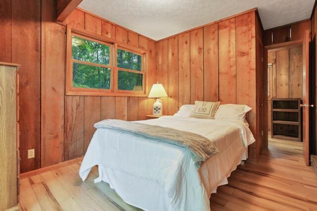 1275 Taos Ln, Sugar Grove, OH 43155 - bedroom featuring wood finished floors, wood walls, and a textured ceiling