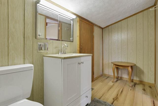 1275 Taos Ln, Sugar Grove, OH 43155 - half bath with wood finished floors, vanity, a textured ceiling, toilet, and wood walls