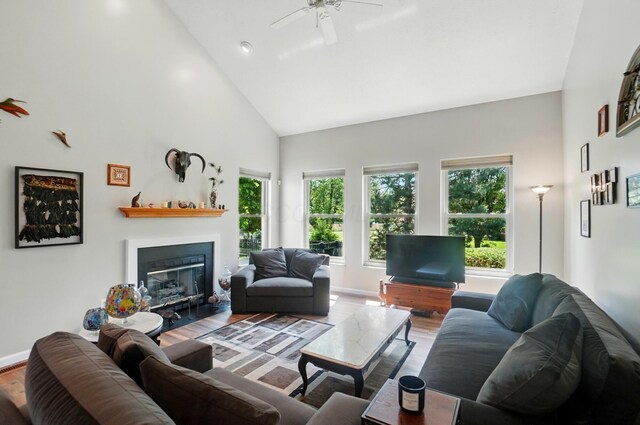 583 Marhurst Ct, Galloway, OH 43119 - living area featuring high vaulted ceiling, wood finished floors, a glass covered fireplace, ceiling fan, and baseboards