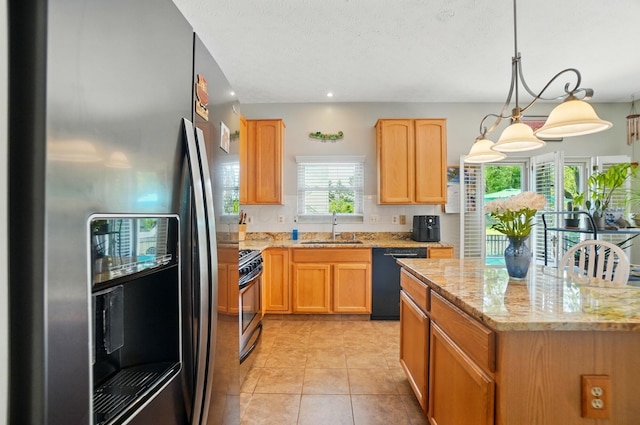 583 Marhurst Ct, Galloway, OH 43119 - kitchen with stainless steel refrigerator with ice dispenser, black dishwasher, a sink, light stone counters, and gas stove