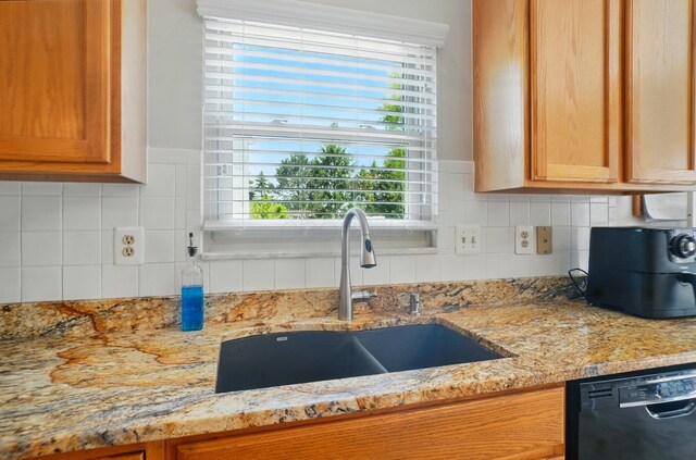 583 Marhurst Ct, Galloway, OH 43119 - kitchen with dishwashing machine, a sink, light stone countertops, and decorative backsplash