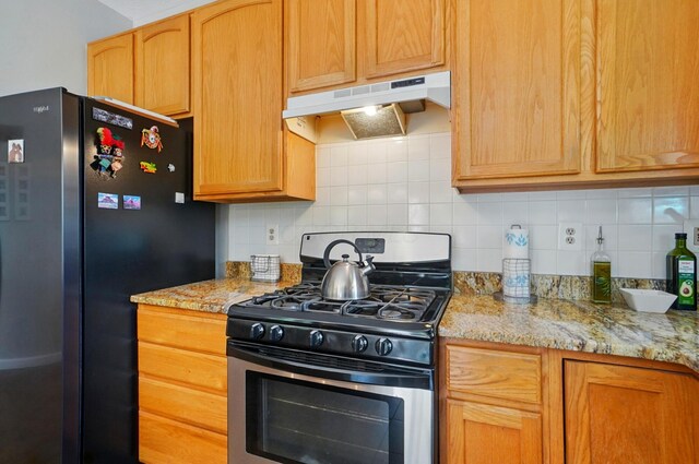 583 Marhurst Ct, Galloway, OH 43119 - kitchen featuring stainless steel appliances, under cabinet range hood, decorative backsplash, and light stone countertops