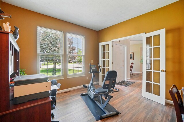583 Marhurst Ct, Galloway, OH 43119 - exercise area with french doors, wood finished floors, and baseboards