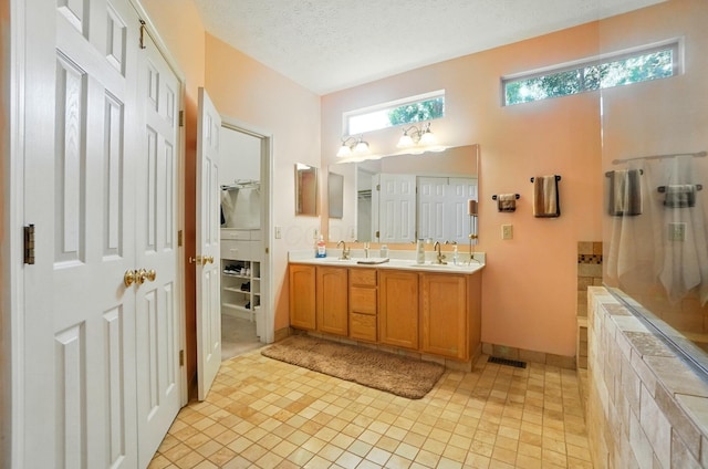 583 Marhurst Ct, Galloway, OH 43119 - bathroom featuring double vanity, baseboards, a textured ceiling, tile patterned floors, and a shower