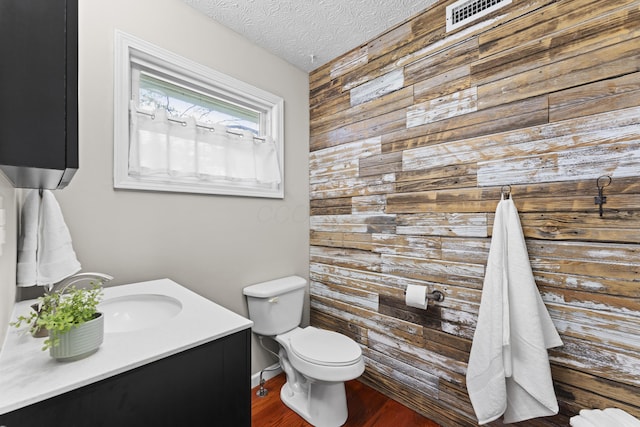 2147 Summit View Rd, Powell, OH 43065 - bathroom featuring wood walls, vanity, toilet, wood finished floors, and a textured ceiling