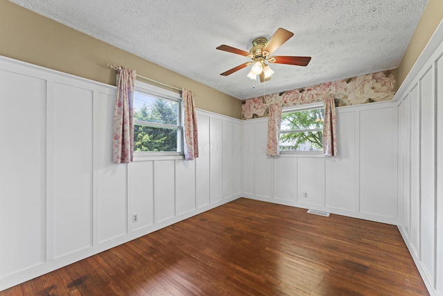 2147 Summit View Rd, Powell, OH 43065 - unfurnished bedroom with a decorative wall, a textured ceiling, dark wood-style floors, ceiling fan, and a wainscoted wall