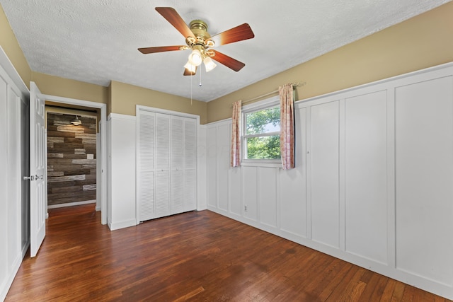 2147 Summit View Rd, Powell, OH 43065 - unfurnished bedroom with wood finished floors, a decorative wall, a ceiling fan, and a textured ceiling