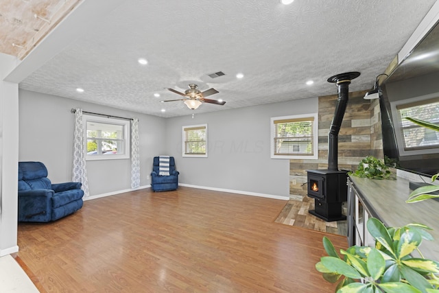 2147 Summit View Rd, Powell, OH 43065 - sitting room featuring recessed lighting, light wood-style flooring, a textured ceiling, baseboards, and a wood stove