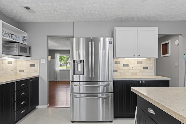 2147 Summit View Rd, Powell, OH 43065 - kitchen with appliances with stainless steel finishes, a textured ceiling, dark cabinets, light countertops, and white cabinets