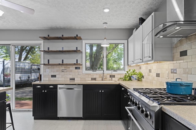 2147 Summit View Rd, Powell, OH 43065 - kitchen with appliances with stainless steel finishes, wall chimney exhaust hood, dark cabinets, a textured ceiling, and light wood-type flooring