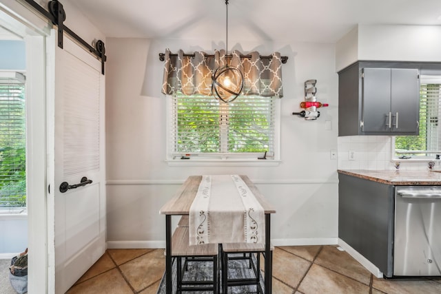 2171 Northam Rd, Columbus, OH 43221 - dining space with a barn door, healthy amount of natural light, light tile patterned floors, and baseboards