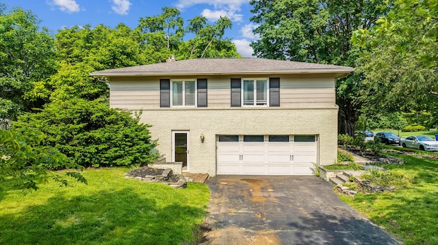 2171 Northam Rd, Columbus, OH 43221 - view of front of home featuring an attached garage, asphalt driveway, brick siding, and a front lawn