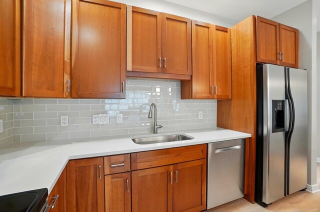 250 Daniel Burnham Sq Unit 304, Columbus, OH 43215 - kitchen with stainless steel appliances, light countertops, backsplash, and brown cabinets