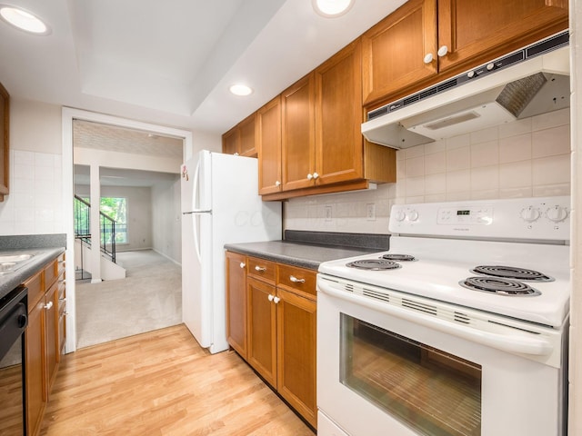 3120 Walden Ravines, Columbus, OH 43221 - kitchen featuring white appliances, under cabinet range hood, dark countertops, brown cabinetry, and light wood-style flooring