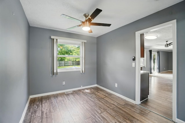 2605 Bella Via Ave, Columbus, OH 43231 - empty room featuring a ceiling fan, healthy amount of natural light, baseboards, wood finished floors, and a textured ceiling