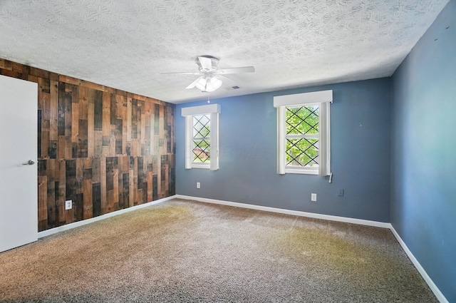 2605 Bella Via Ave, Columbus, OH 43231 - empty room featuring wooden walls, a ceiling fan, carpet flooring, baseboards, and a textured ceiling