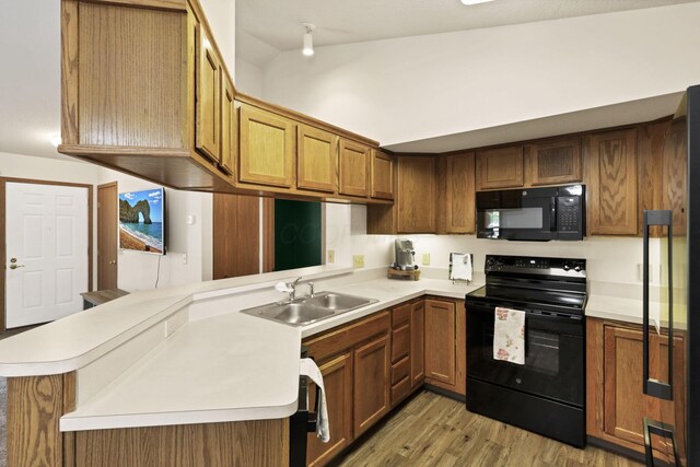 1318 Hillview Cir E, Newark, OH 43055 - kitchen featuring black appliances, a sink, light wood-type flooring, a peninsula, and light countertops
