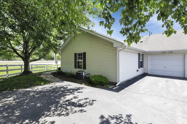 1318 Hillview Cir E, Newark, OH 43055 - view of side of home featuring a garage, driveway, and cooling unit