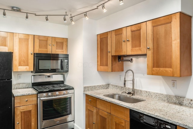 1775 NW Ct Unit 114 J, Columbus, OH 43212 - kitchen with black appliances, a sink, light stone countertops, rail lighting, and brown cabinets