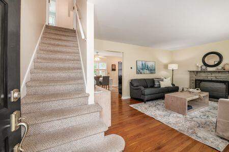 677 E Weisheimer Rd, Columbus, OH 43214 - living area featuring stairs, wood finished floors, a fireplace, and baseboards