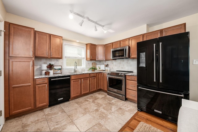 677 E Weisheimer Rd, Columbus, OH 43214 - kitchen with black appliances, a sink, brown cabinetry, and decorative backsplash
