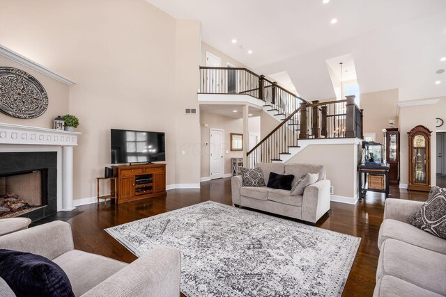 7908 Coldwater Dr, Powell, OH 43065 - living room with a high ceiling, stairs, a fireplace with flush hearth, dark wood-type flooring, and recessed lighting