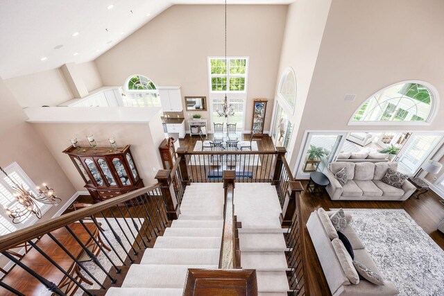 7908 Coldwater Dr, Powell, OH 43065 - stairs featuring high vaulted ceiling, wood finished floors, recessed lighting, and a chandelier