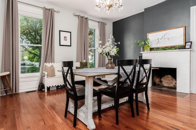369 E Main St, Circleville, OH 43113 - dining space featuring a chandelier, wood finished floors, and a brick fireplace