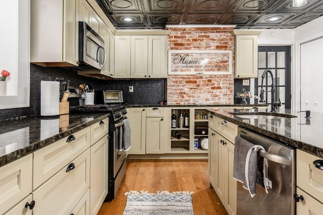 369 E Main St, Circleville, OH 43113 - kitchen featuring stainless steel appliances, a sink, an ornate ceiling, backsplash, and light wood-type flooring