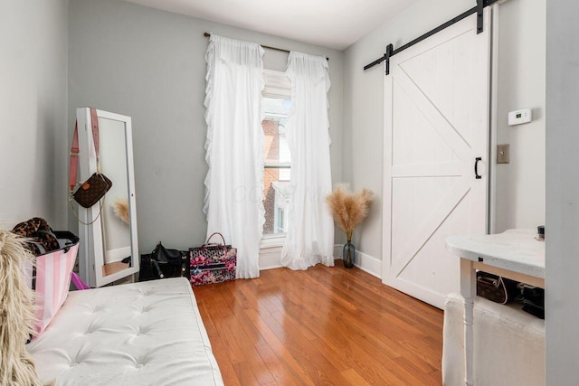 369 E Main St, Circleville, OH 43113 - bedroom featuring a barn door, light wood finished floors, and baseboards