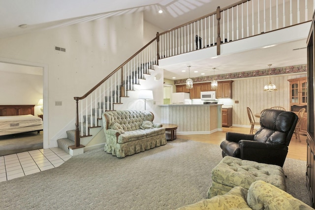 53 Stone House Ct, Newark, OH 43055 - living area featuring stairs, a towering ceiling, baseboards, a chandelier, and light colored carpet