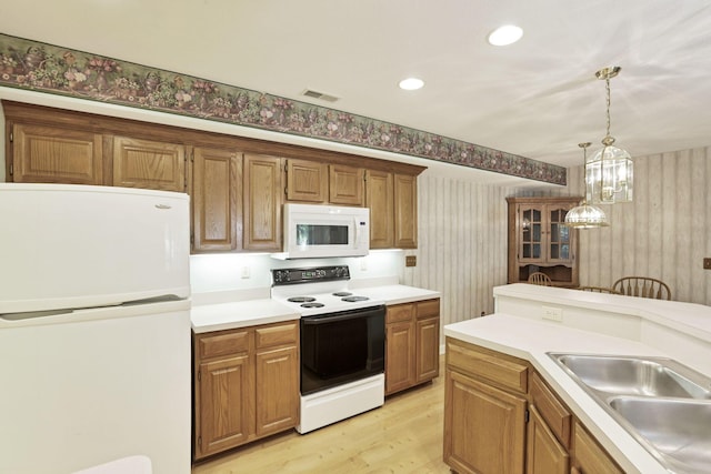 53 Stone House Ct, Newark, OH 43055 - kitchen featuring white appliances, light wood-style flooring, decorative light fixtures, wallpapered walls, and light countertops