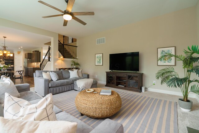 829 Pathlow Dr, Pickerington, OH 43147 - living area featuring stairway, a chandelier, a ceiling fan, and carpet flooring