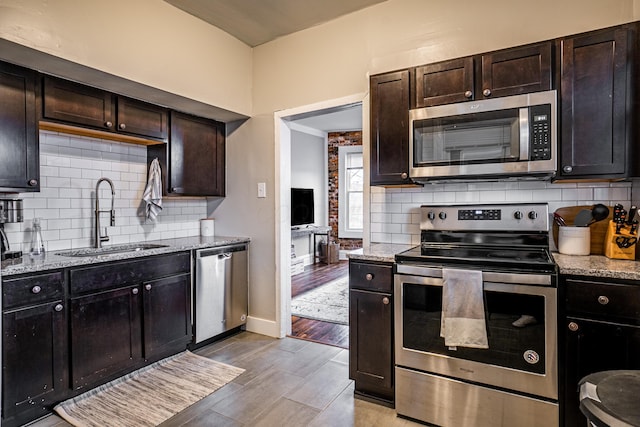 382 Carpenter St, Columbus, OH 43205 - kitchen featuring appliances with stainless steel finishes, a sink, light wood-style flooring, and decorative backsplash