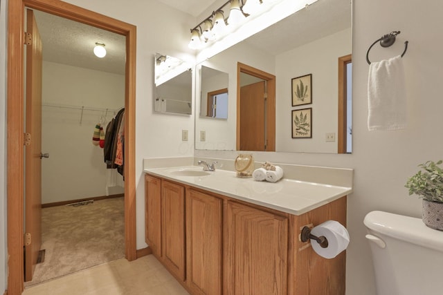 1993 Schrive Dr, Hilliard, OH 43026 - bathroom featuring vanity, toilet, a spacious closet, and baseboards