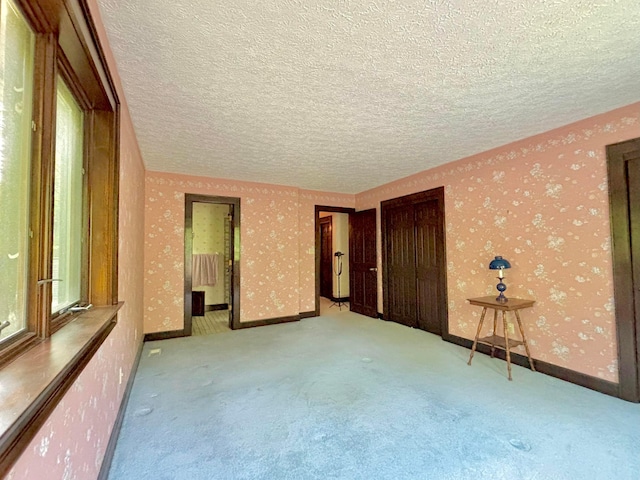 5401 Plantation Rd, Sunbury, OH 43074 - unfurnished bedroom featuring carpet flooring, a textured ceiling, wallpapered walls, a closet, and baseboards