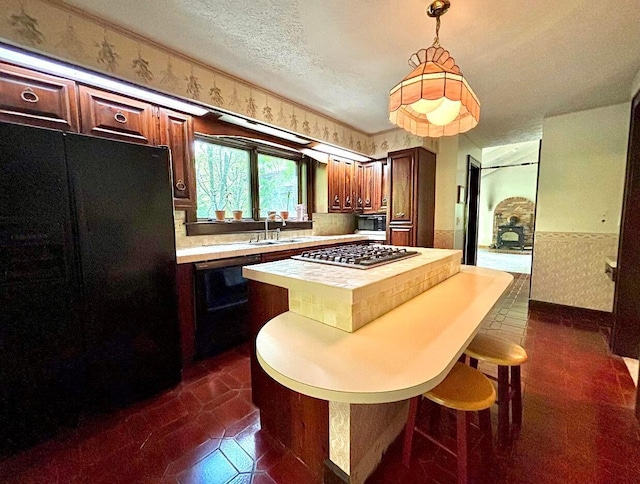 5401 Plantation Rd, Sunbury, OH 43074 - kitchen with black appliances, light countertops, a center island, a kitchen breakfast bar, and hanging light fixtures