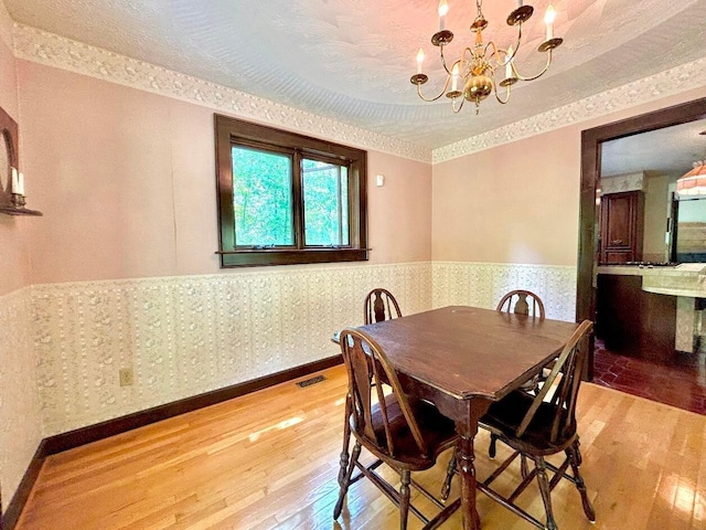 5401 Plantation Rd, Sunbury, OH 43074 - dining space featuring light wood-type flooring, a chandelier, and a wainscoted wall