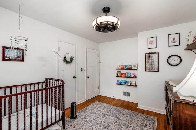 410 Acton Rd, Columbus, OH 43214 - bedroom with wood finished floors and a crib