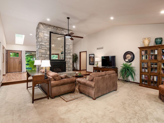 5769 Royal Lytham Ct, Dublin, OH 43017 - carpeted living area with lofted ceiling, a stone fireplace, a ceiling fan, recessed lighting, and a skylight