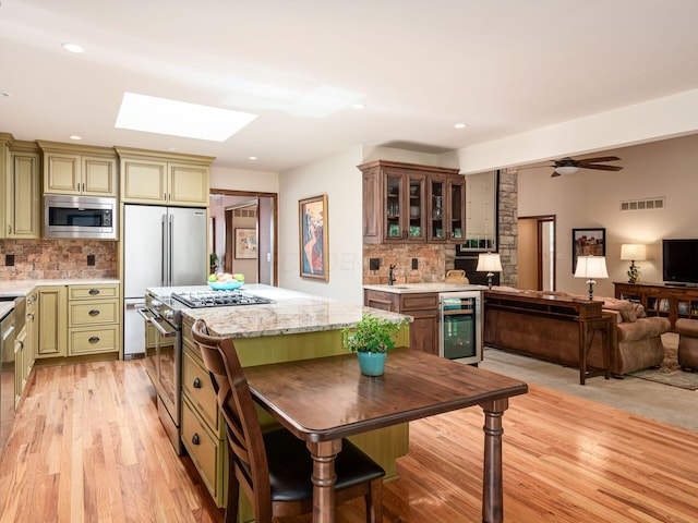 5769 Royal Lytham Ct, Dublin, OH 43017 - kitchen featuring stainless steel appliances, beverage cooler, light wood-type flooring, backsplash, and recessed lighting