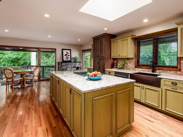 5769 Royal Lytham Ct, Dublin, OH 43017 - kitchen featuring a sink, a center island, light wood-type flooring, light stone countertops, and recessed lighting