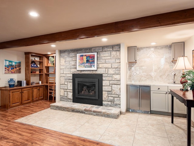 5769 Royal Lytham Ct, Dublin, OH 43017 - living room with beamed ceiling, recessed lighting, light wood-type flooring, a stone fireplace, and a bar