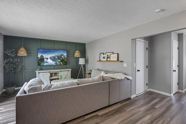 840 Gulliver Dr, Columbus, OH 43207 - living room with dark wood-style flooring, baseboards, a textured ceiling, and an accent wall