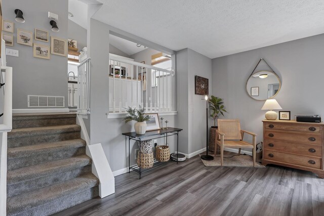 840 Gulliver Dr, Columbus, OH 43207 - entrance foyer featuring wood finished floors, baseboards, stairs, vaulted ceiling, and a textured ceiling