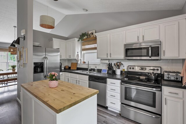 840 Gulliver Dr, Columbus, OH 43207 - kitchen featuring stainless steel appliances, vaulted ceiling, a sink, plenty of natural light, and white cabinets